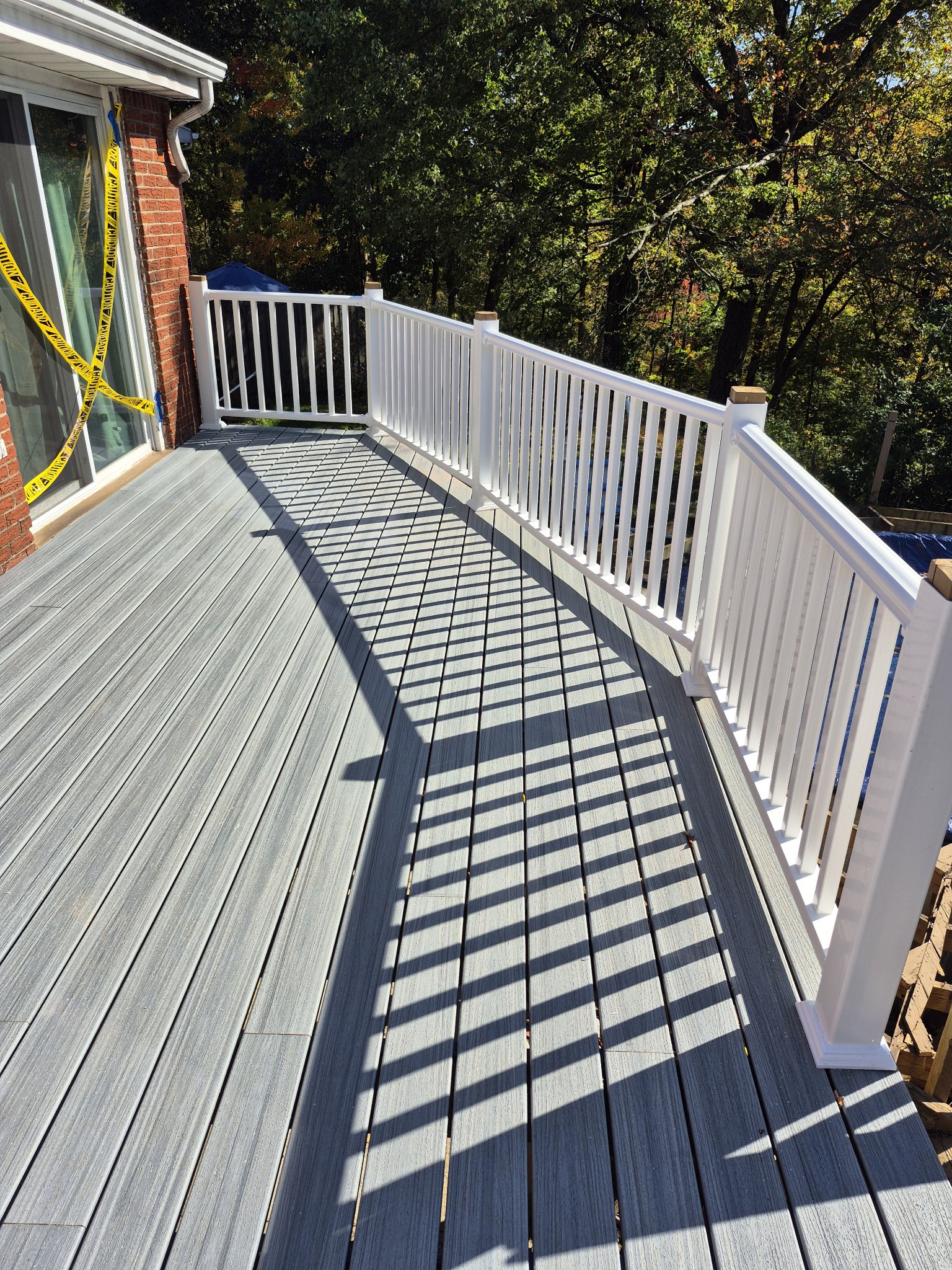 New gray composite deck boards with white railings after rebuild