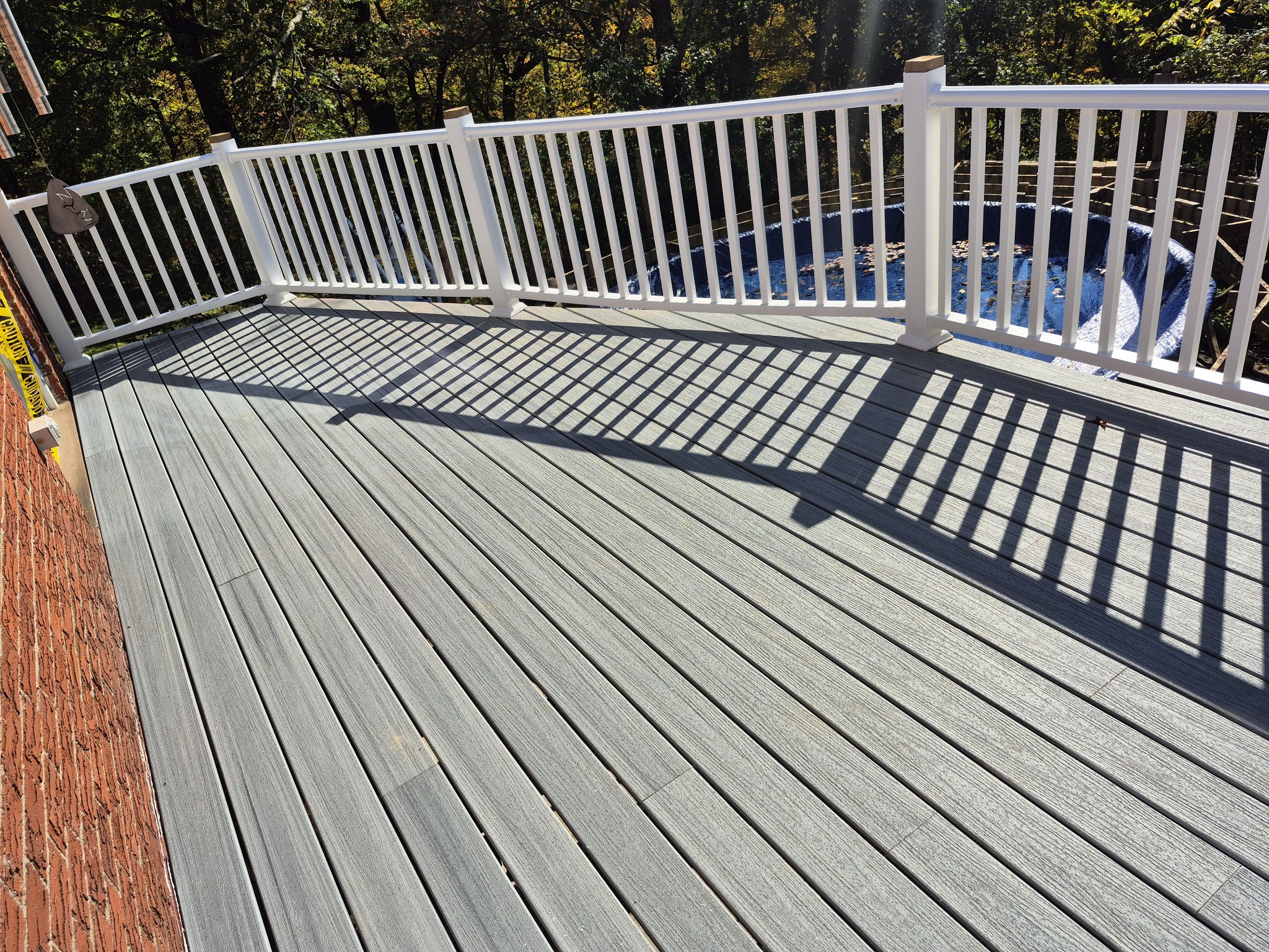 Completed deck rebuild with composite decking against brick home