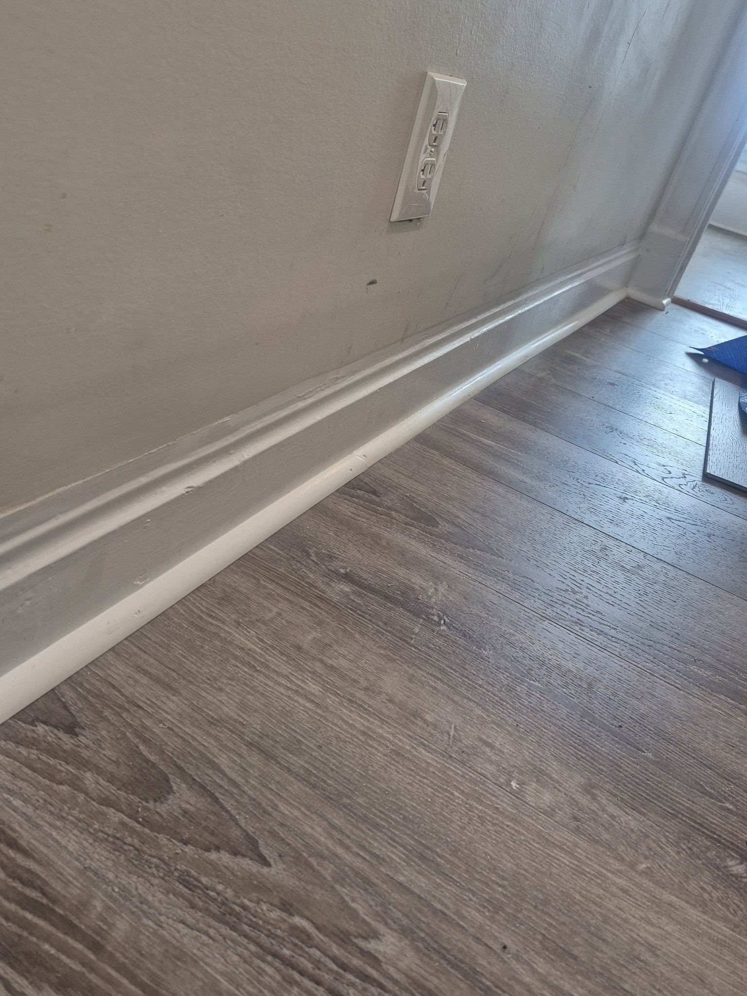 New baseboard trim with luxury vinyl plank flooring and fresh paint