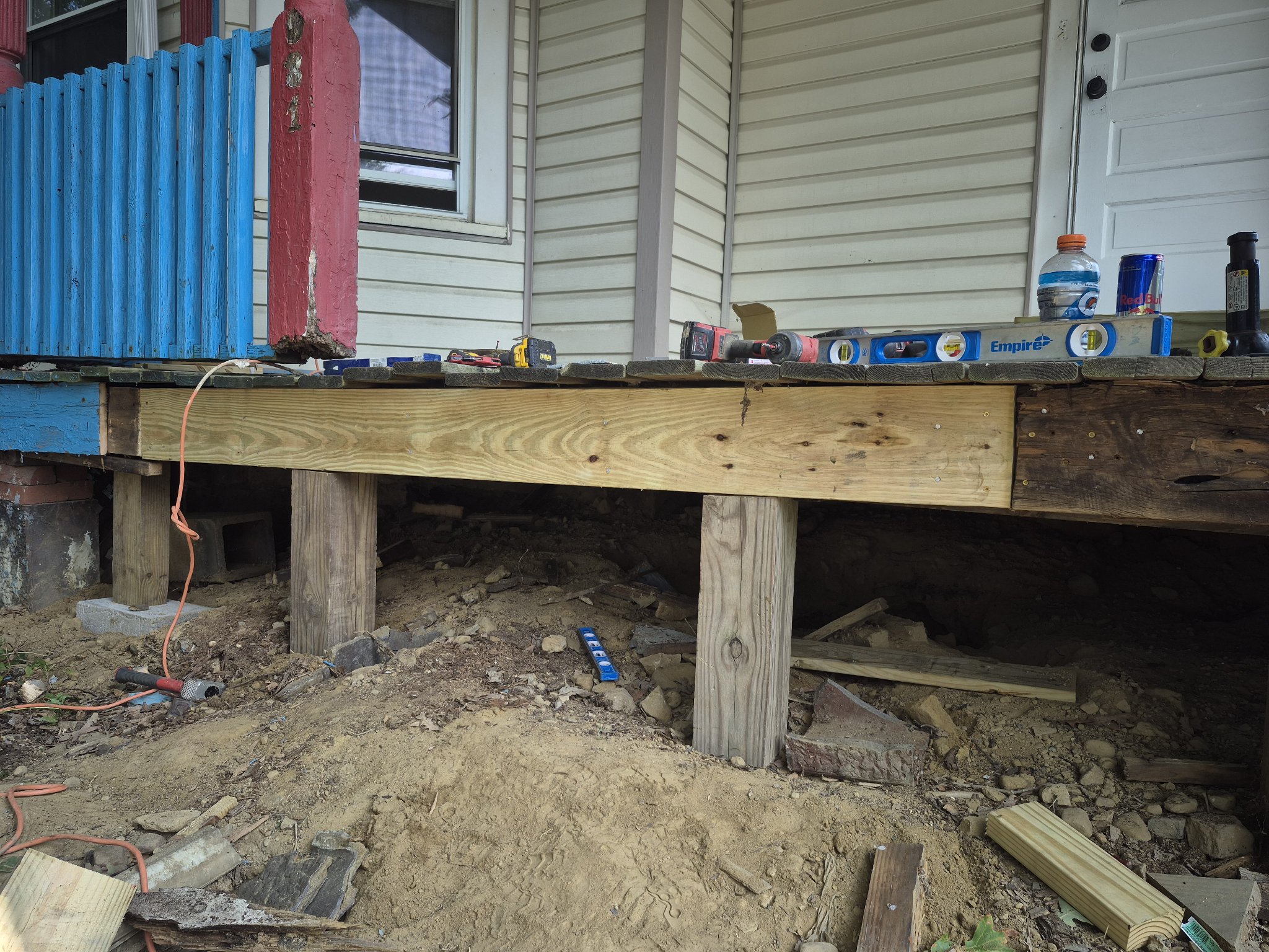 New structural beam and posts installed under a porch during repair