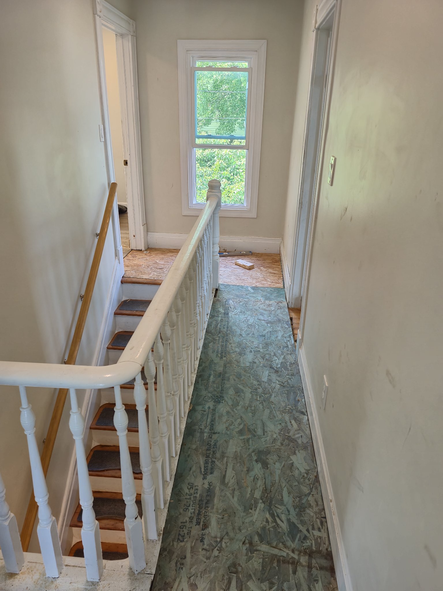 New OSB subfloor installed in upstairs hallway during bathroom-adjacent flooring job